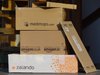 Stapel mit Paketen der Online-Versandhändlern amazon, zalando und medimops.
