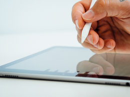 Elektronische Signatur: Eine Hand hält einen Stift und leistet am tablet eine digitale Unterschrift.