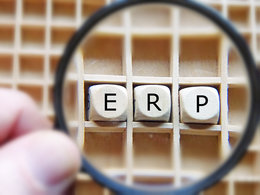 Eine Lupe vergrößert die Buchstaben ERP, die für Enterprise Resource Planning stehen.