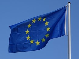 EU-Jobbörse: Die EU-Flagge flattert bei blauem Himmel im Sonnenschein.