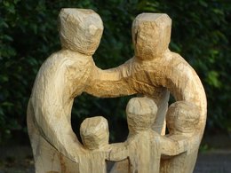 Eine Familie mit Vater, Mutter und drei Kindern aus Holz.