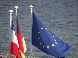 Die europäisch, deutsche und französische Flagge vor der Ostsee.