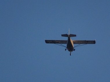 Ein Doppeldeckermotorflugzeug fliegt vor blauem Himmel.