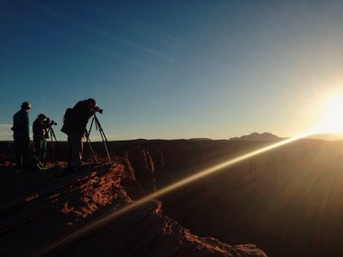 Fotografen stehen mit ihren Kameragestellen am Rand des Grand Canyons.