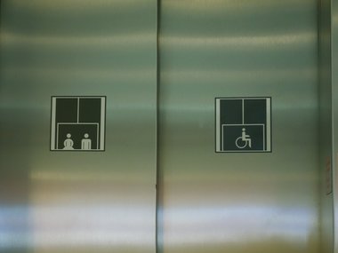 Ein Fahrstuhl mit einem Symbol für einen Personen- und einen Behindertentransport.