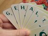 Eine Hand hält gefächerte Karten mit Buchstaben, die das Wort Gehalt ergeben.