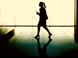 Gehaltsentwicklung Führungskräften: Eine Managerin läuft einen Gang entlang. 
