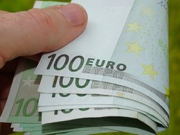 Ein Hand hält ein Bündel 100 Euro Geldscheine.