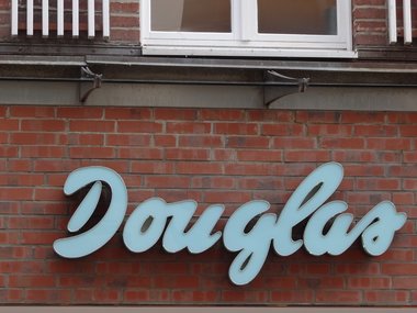 Der Schriftzug von dem Geschäft Douglas an einer roten Backsteinwand.