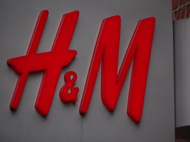 Der Schriftzug von dem Geschäft H&M in rot auf einem weißen Schild.