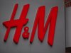 Der Schriftzug von dem Geschäft H&M in rot auf einem weißen Schild.
