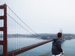Ein junger Mann schaut auf die Golden Gate Brücke.