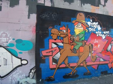 Das Graffiti von einer Comicfigur als Cowboy auf einem Pferd.