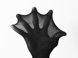 Eine Hand in einer dunklen Nylonstrumpfhose.