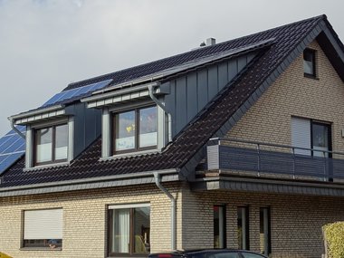 Ein Wohnhaus mit Solaranlage auf dem Dach.