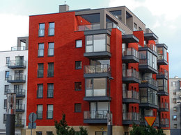 Hypothek: Ein rotes Haus mit Wohnungen und Balkonen