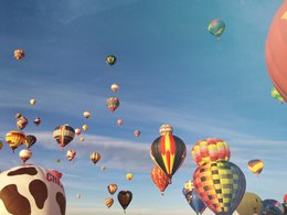 Fahrende und startende, farbenfrohe Heißluftballons.