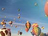 Fahrende und startende, farbenfrohe Heißluftballons.