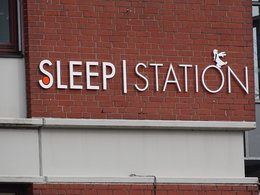 Sleep Station, der Name eines Hotels an einer roten Backsteinwand.