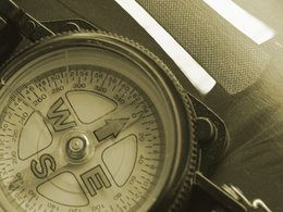 Ein Kompass und ein Teil von einer Kravatte, Hemd und Anzug symbolisieren das Thema Personalstrategie.