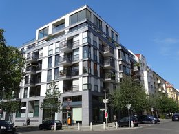 Immobilienverwaltungssoftware: Das Bild zeigt ein modernes mehrstöckiges Wohnhaus mit zahlreichen Wohnungen mit Balkonen.