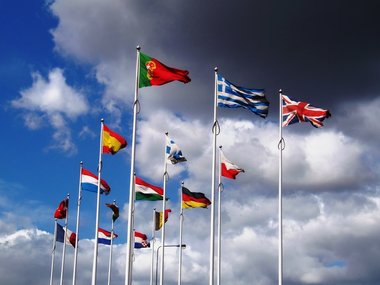 International-EU-Flaggen an langen Fahnenmasten.