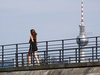 Work-Life-Balance: Der Alexanderturm in Berlin mit einer Frau die in ihrer Freizeit joggt.