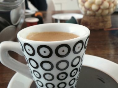 Eine Tasse Kaffee mit schwarzen Kreisen.