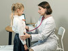 Das Bild zeigt eine Kinderkrankenschwester beim Abhören eines Kindes mit dem Stetoskop.