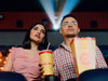 Das Foto zeigt ein Pärchen mit Popcorn und Cola im Kino.