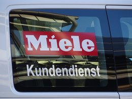 Das Bild zeigt das Wort "Kundendienst" am Autofenster eines Fahrzeugs vom Kundenservice der Firma Miele.