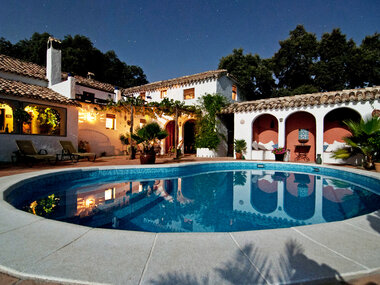 Das Bild zeigt eine Luxusvilla mit Pool am Abend auf Mallorca.