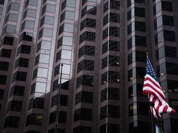 Eine amerikanische Flagge weht vor einem Hochhaus Bürogebäude.
