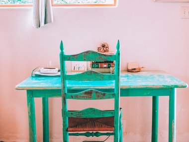 Ein grüner Schreibtisch mit Stuhl.