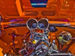 Ein glänzender Motor in einer orangfarbenen Motorhaube.