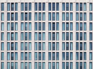 Büro-Immobilie - Ein Bild voller identischer Fenster eines großen Gebäudes.