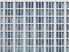 Büro-Immobilie - Ein Bild voller identischer Fenster eines großen Gebäudes.