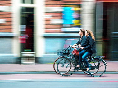Umweltbewusstsein im Studium: Zwei Studentinnen fahren auf dem Fahrrad.