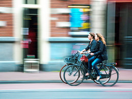 Umweltbewusstsein im Studium: Zwei Studentinnen fahren auf dem Fahrrad.