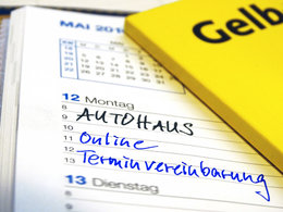 Notizen im Terminkalender zur "Online-Terminvereinbarung" mit dem "AUTOHAUS". Am Bildrand liegt das Branchenbuch "Gelbe Seiten".