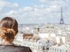Eine Frau schaut über Paris zum Eiffelturm.