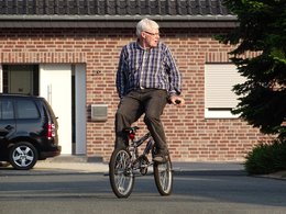 Ein rüstiger Rentner fährt rückwärts auf einem Mountainbike.
