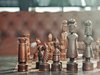 Schachfiguren aus Holz stehen sich gegenüber.