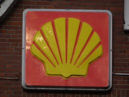 Das rot-gelbe Schild und Markenzeichen von Shell an einer roten Backsteinwand.