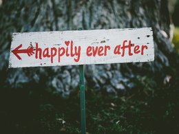 Ein Spruch auf einem weißen Schild mit roter Schrift: happily ever after.