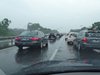 Pendeln: Ein Autobahnstau von hinten im Regen durch eine Scheibe abgelichtet.