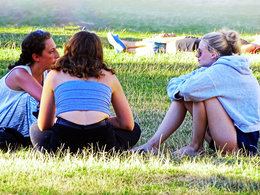 Studenten: Eine Gruppe Studentinnen sitzen im Kreis auf einer Wiese.
