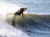 Ein Surfer, der mit seinem Brett auf einer Welle reitet.