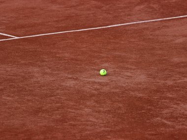 Der Ausschnitt eines Tennisfeldes mit weißen Linien.
