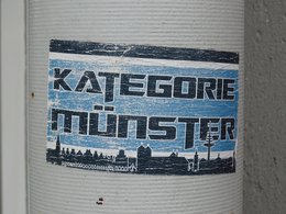 Ein Aufkleber auf einer Straßenlaterne mit der Aufschrift: Kategorie Münster.